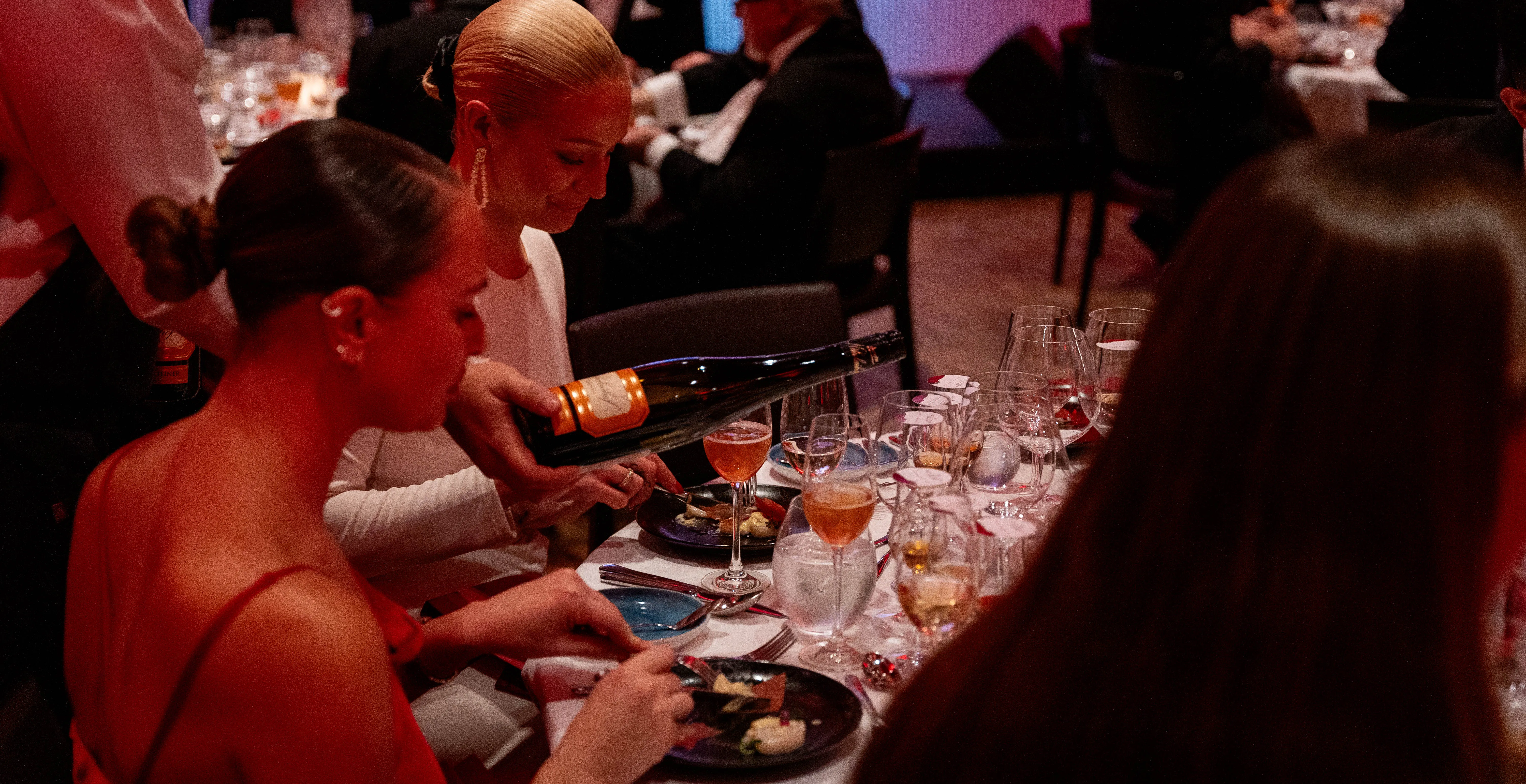 Gjester ved middagsbordet i rødt lys på Ekebergrestauranten