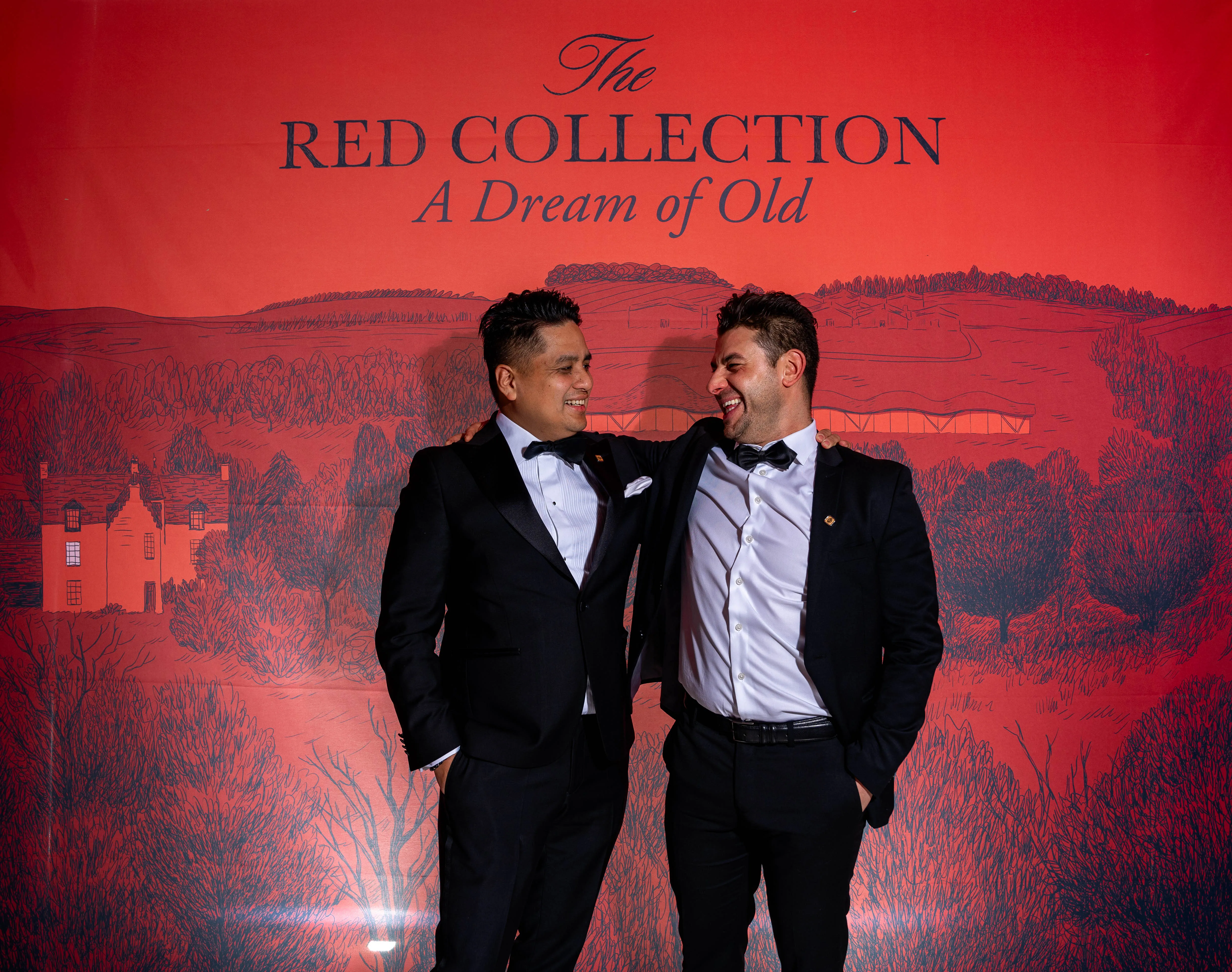 To gjester i smoking foran Red Collection-veggen