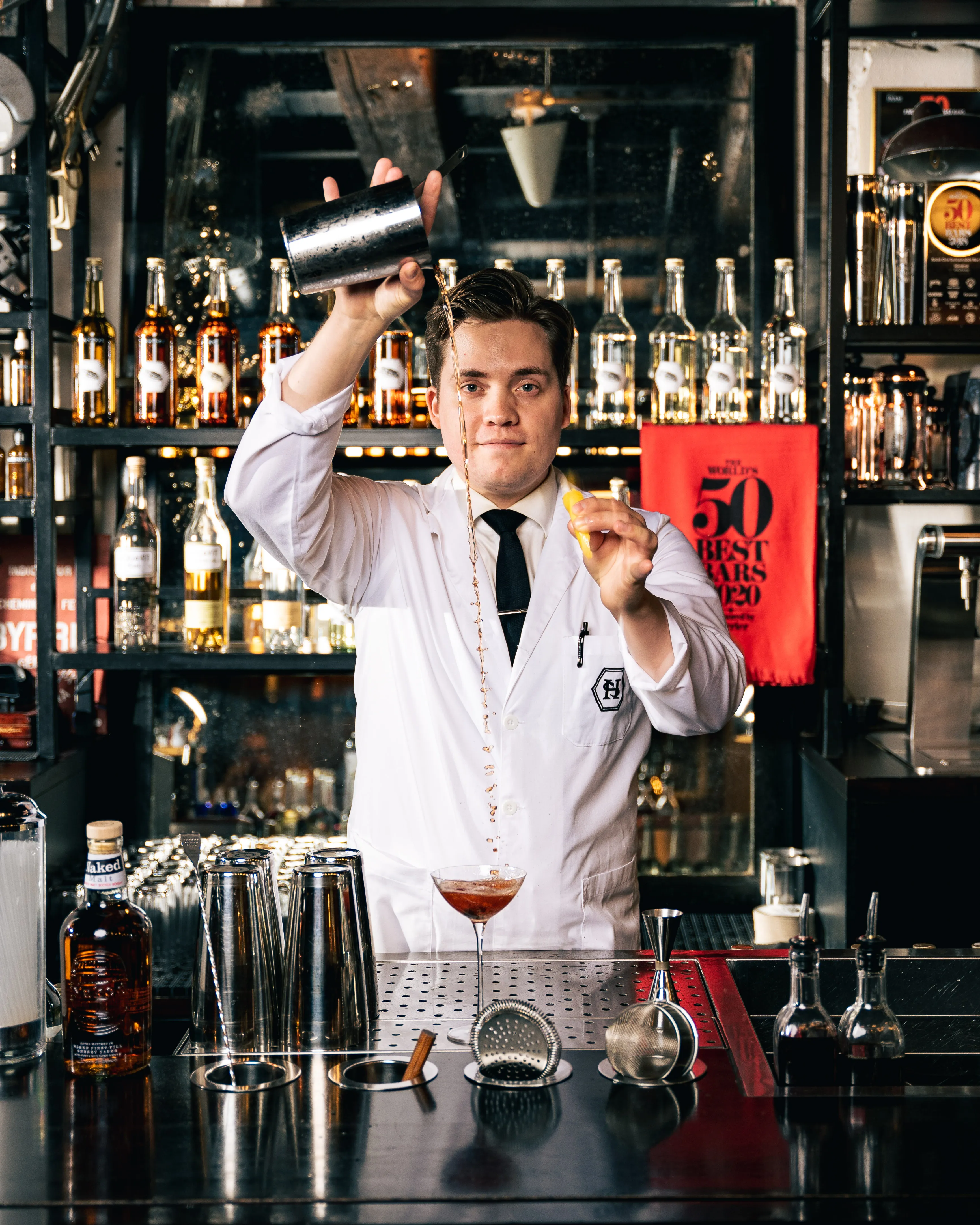 Bartender på Himkok heller i en lang stråle mot et glass
