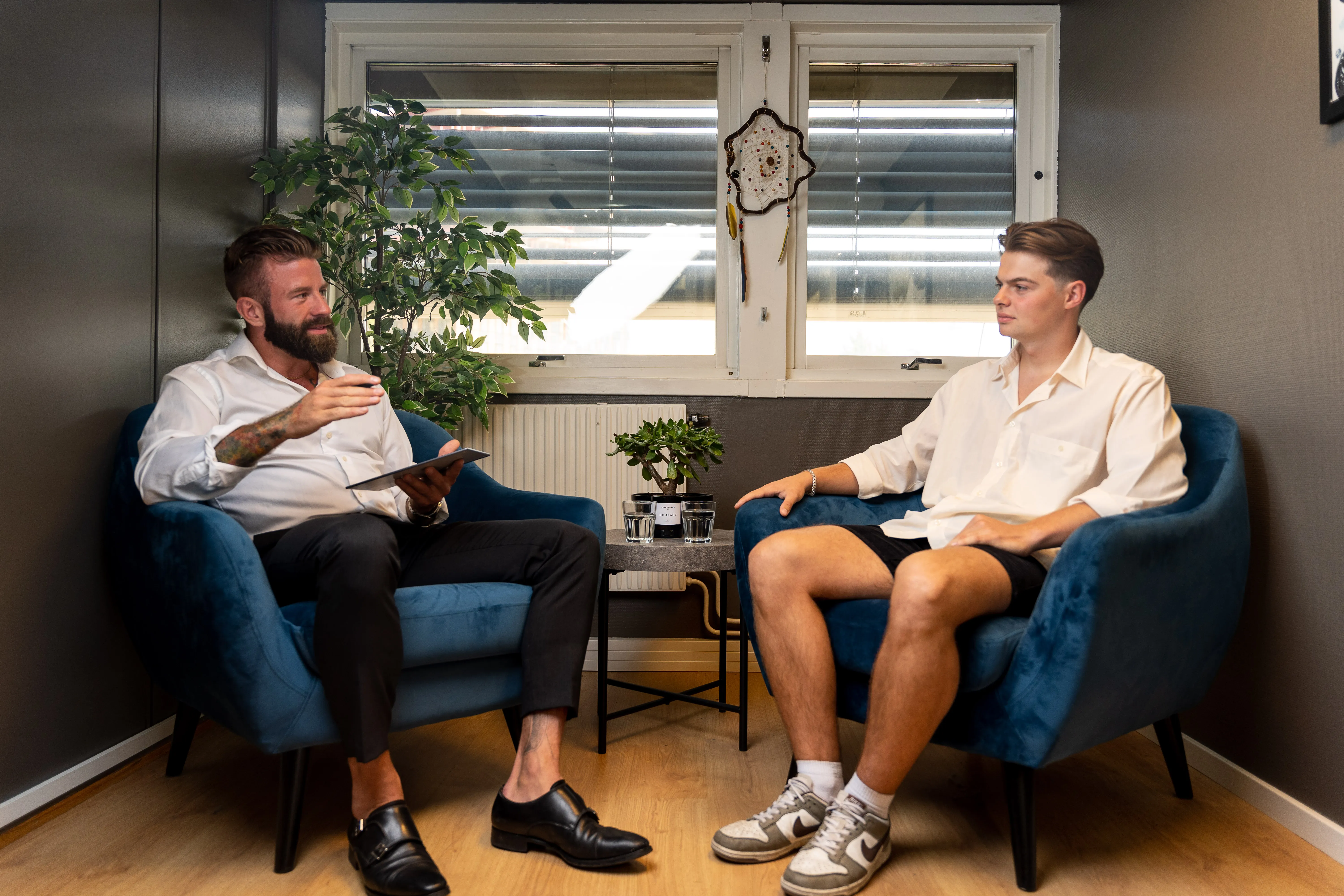 Aleksander Stormskjold i samtale med en kunde i to lenestoler