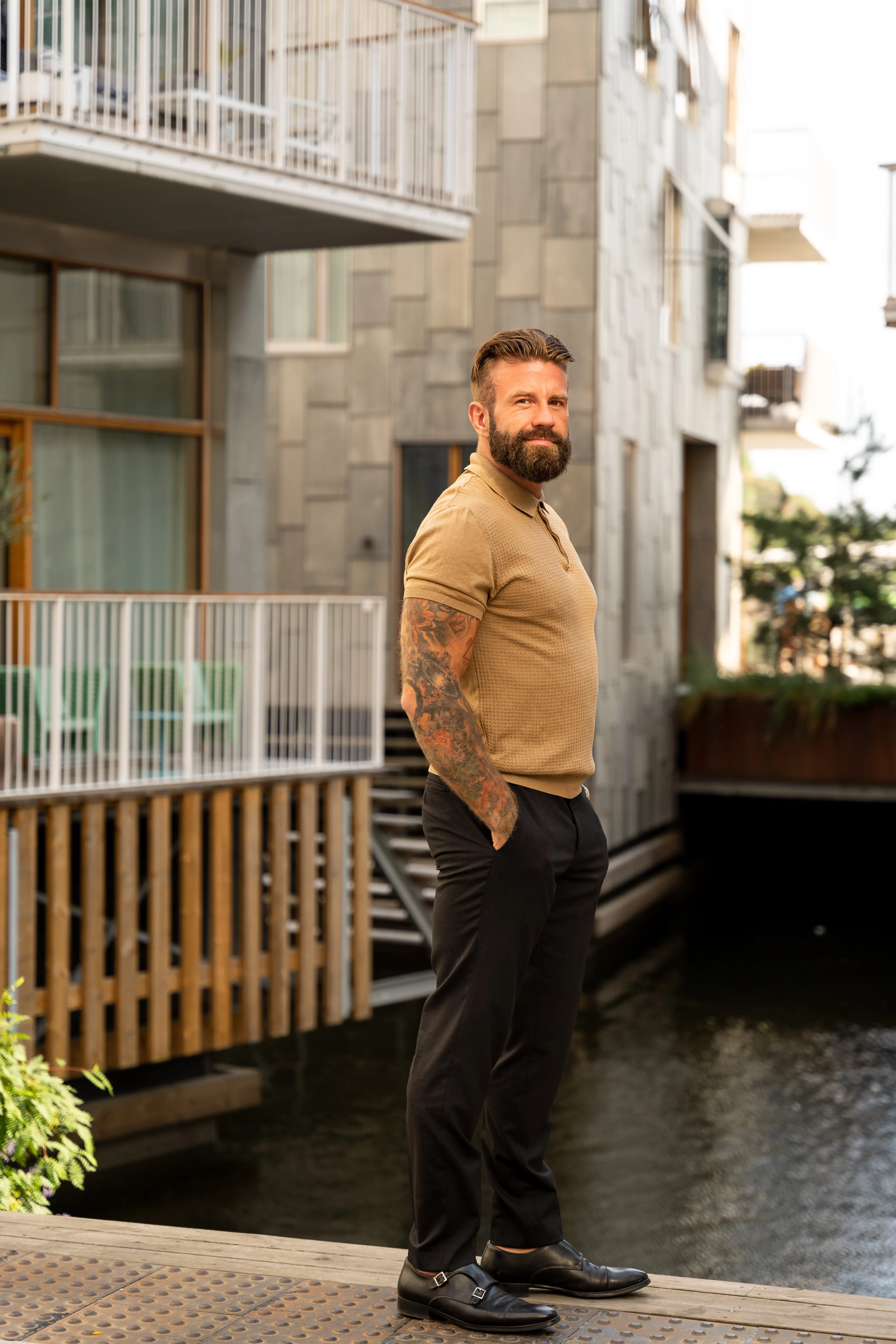 Aleksander Stormskjold står ved en kanal mellom boligbygg