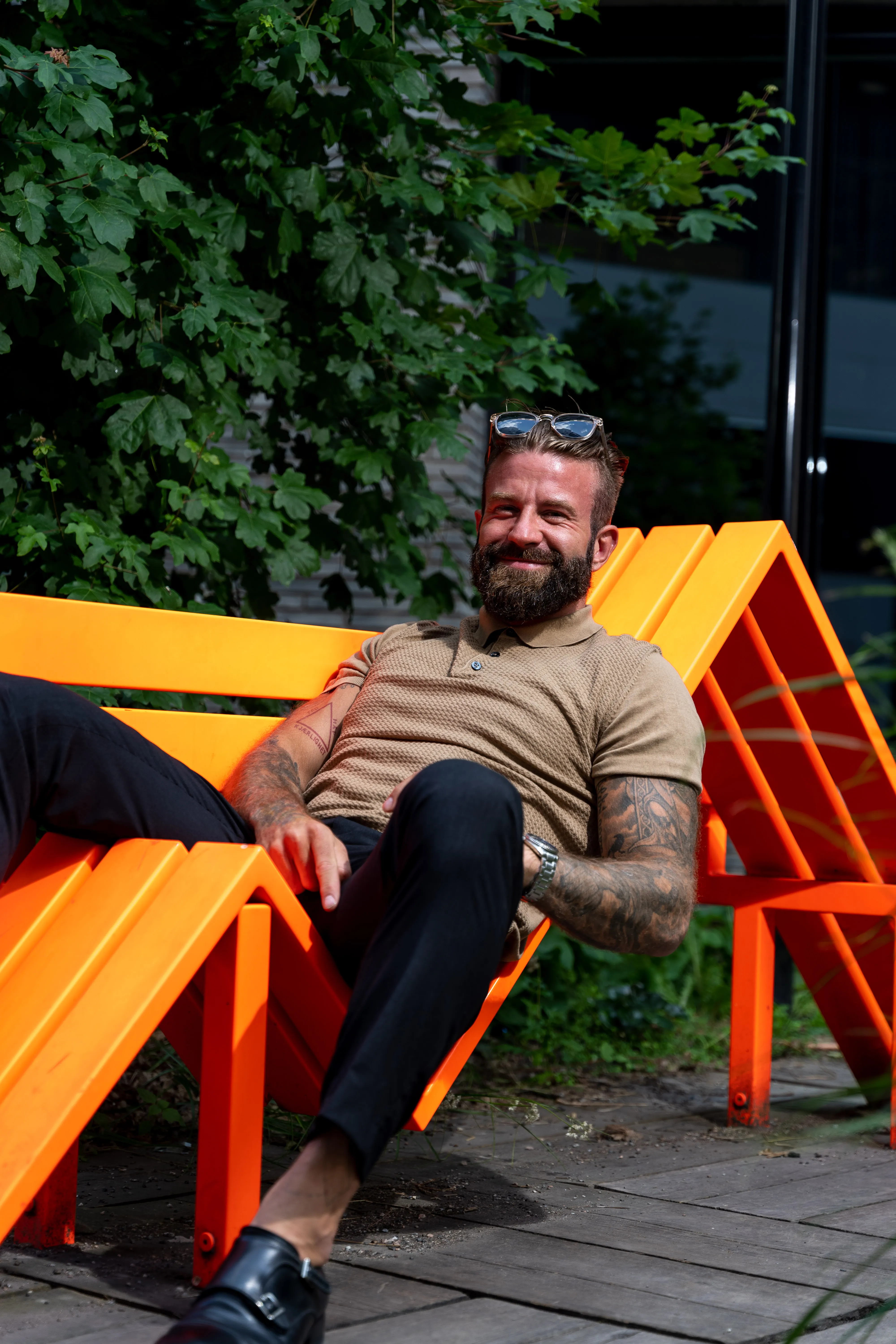Aleksander Stormskjold ligger avslappet på en oransje benk
